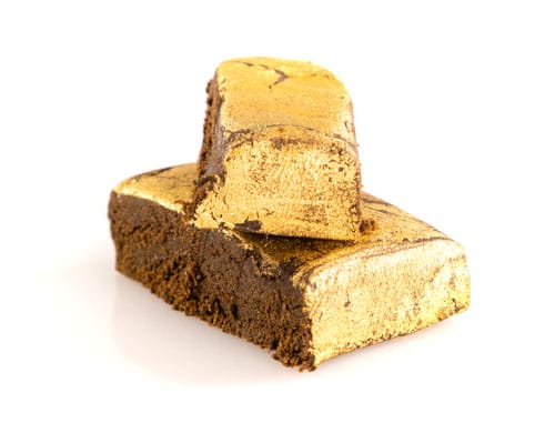 Two-Pieces-CBD Hash-gold Two pieces of legal hash covered with a film of gold